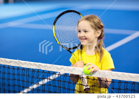Child playing tennis on indoor court 43700525