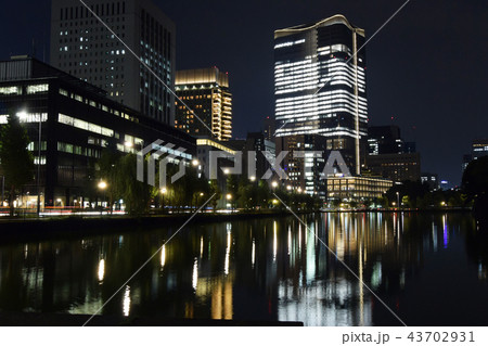 東京駅周辺のビル群の夜景と皇居の水面の映りこみ 43702931