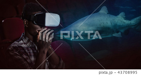 Composite image of man wearing virtual reality headset in theater 43708995