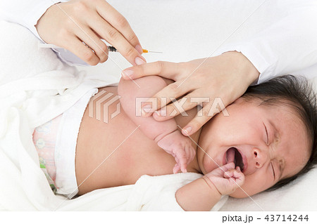 医師 看護師 により腕に注射を打たれ泣いている新生児の赤ちゃん 予防接種 インフルエンザ 病気 治療の写真素材
