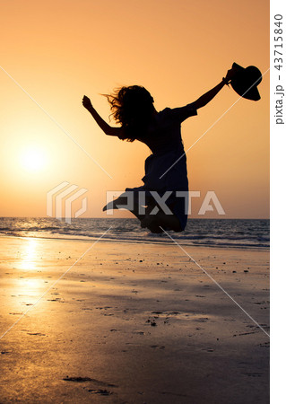 Girl jumping on the beach at sunset 43715840
