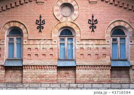 three vintage arched windows in a wall of yellow bricks. Green - the colors of sea wave glass in a 43716594
