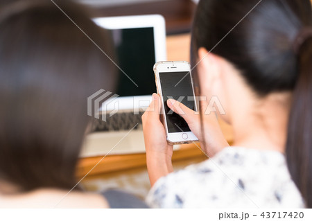 ノートパソコンを操作する女性二人 43717420