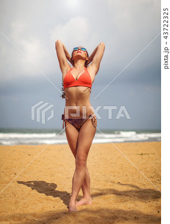 Young woman in red swimsuit and sunglasses 43722325