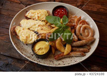 Grilled assorted sausages with French fries, bruschettes with cheese and sauces. Grilled assorted sausages with French fries, bruschettes with cheese and sauces. 43724100