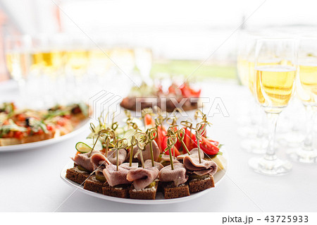 rye bread sandwiches, canapes, bruschetta on white plate. solemn banquet. Lot of glasses champagne rye bread sandwiches, canapes, bruschetta on white plate. solemn banquet. Lot of glasses champagne 43725933
