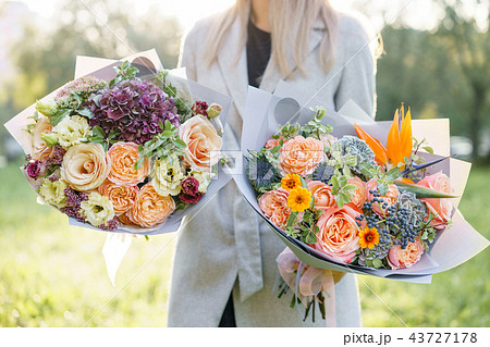 two beautiful spring bouquet. Young girl holding a flowers arrangements with variety of colors two beautiful spring bouquet. Young girl holding a flowers arrangements with variety of colors 43727178