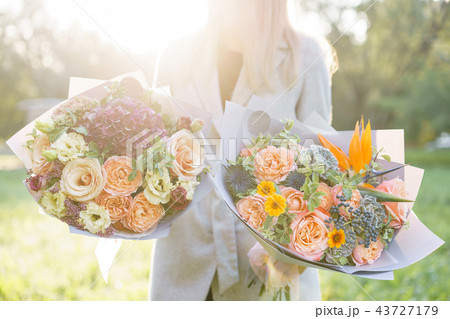 two beautiful spring bouquet. Young girl holding a flowers arrangements with variety of colors two beautiful spring bouquet. Young girl holding a flowers arrangements with variety of colors 43727179
