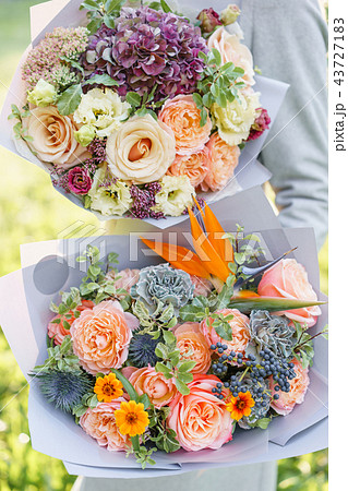two beautiful spring bouquet. Young girl holding a flowers arrangements with variety of colors two beautiful spring bouquet. Young girl holding a flowers arrangements with variety of colors 43727183