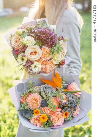 two beautiful spring bouquet. Young girl holding a flowers arrangements with variety of colors 43727185