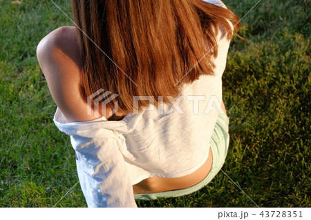 Rear view of redhair teen girl on grass 43728351