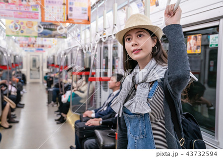 woman standing and holding the handle in train woman standing and holding the handle in train 43732594