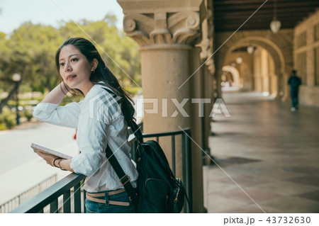 girl leaning on guardrail and looking at people 43732630
