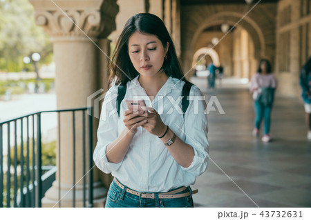 student holding her phone and texting. student holding her phone and texting. 43732631
