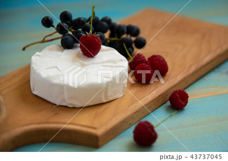 cheese camembert with raspberries and grapes on table 43737045