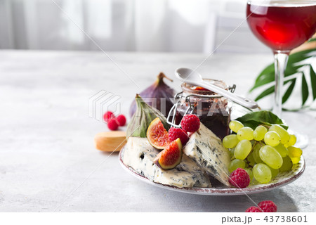 delicacy blue cheeses, fruit and jam in jar with red wine in glass on white stone background, copy delicacy blue cheeses, fruit and jam in jar with red wine in glass on white stone background, copy 43738601
