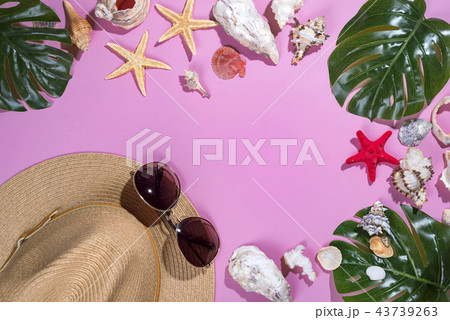 seashells on pastel violet background with straw hat - summer holiday background. Panton color of seashells on pastel violet background with straw hat - summer holiday background. Panton color of 43739263