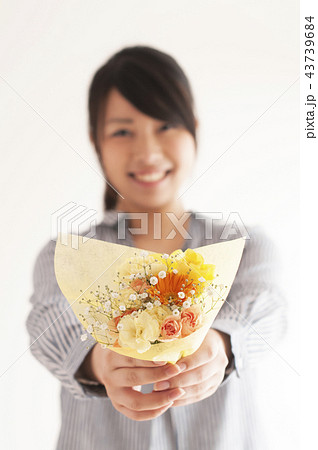 花束を渡す女性の手元の写真素材