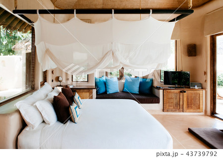Resort bedroom with wooden bed with mosquito net 43739792