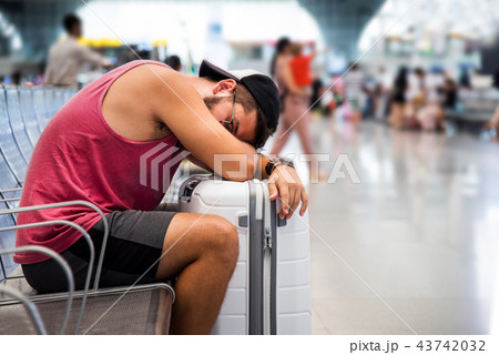 Man sleeping while waiting on the train station Man sleeping while waiting on the train station 43742032