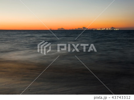 Long exposure shot of dark sea with ships pier 43743312