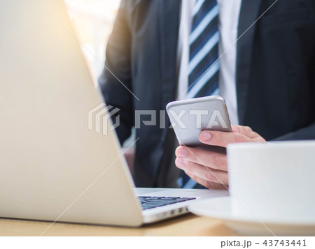 Close up businessman phone working on laptop   43743441