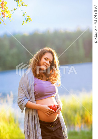 pregnant woman expecting baby red heart outdoors 43743897