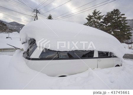 豪雪地域で大雪に埋もれる車で一酸化酸素中毒注意屋根に積もる雪出勤前の雪下ろし 43745661