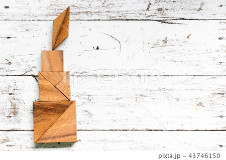 Tangram puzzle in candle shape on white wood Tangram puzzle in candle shape on white wood 43746150