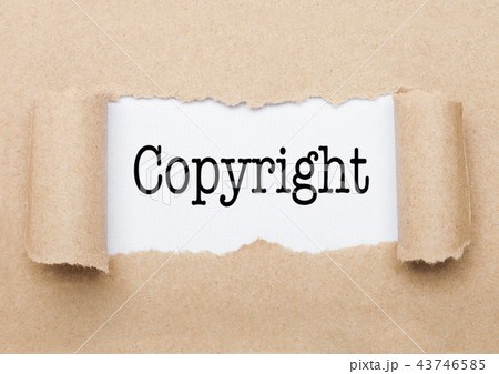 Copyright text appearing behind torn brown paper 43746585