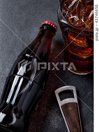 Bottle of cola soda drink and glass with ice cubes 43746656