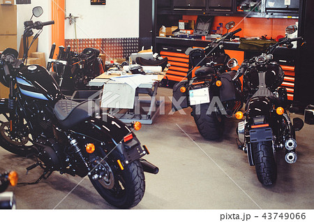 Many motorcycles on the floor with workshop  43749066