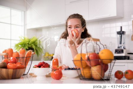 Woman in a kitchen with fruits and juice Woman in a kitchen with fruits and juice 43749147