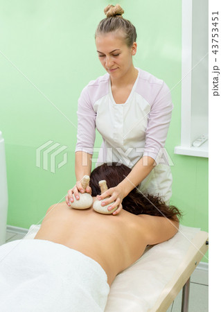 Woman having spa bags massage in wellness salon Woman having spa bags massage in wellness salon 43753451