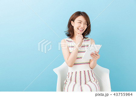 部屋でタブレットを見る女性 部屋でタブレットを見る女性 43755964