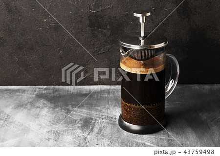 Coffee in french press on dark background Coffee in french press on dark background 43759498