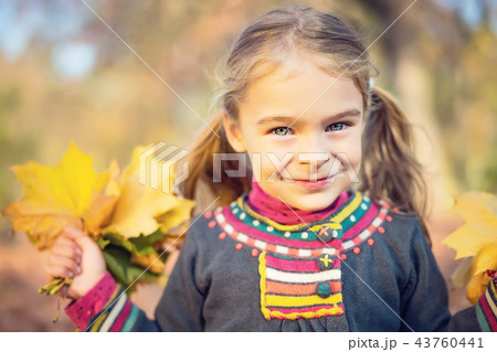 Happy little girl with autumn leaves Happy little girl with autumn leaves 43760441