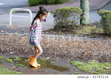 水たまりで遊ぶ女の子の写真素材