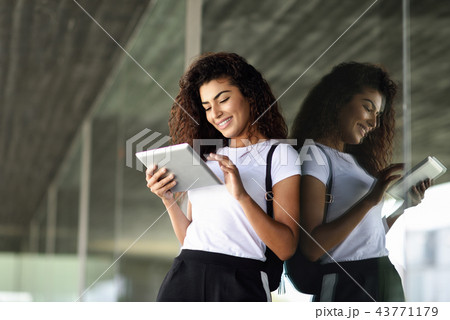 Happy young Arab woman using digital tablet in business backgrou Happy young Arab woman using digital tablet in business backgrou 43771179