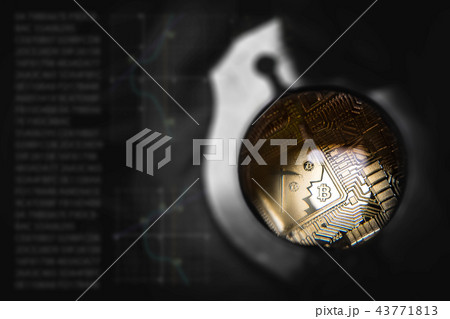 Golden Bitcoin  lies on man hand under loupe.  43771813