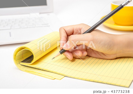 A note taking notes on a notepad in an office A note taking notes on a notepad in an office 43773238