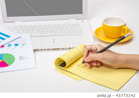 A note taking notes on a notepad in an office 43773242