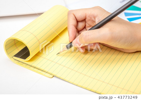 A note taking notes on a notepad in an office A note taking notes on a notepad in an office 43773249