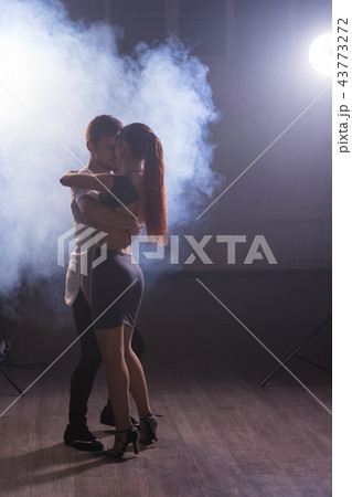 Skillful dancers performing in the dark room under the concert light and smoke. Sensual couple 43773272