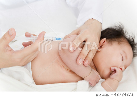 医師 看護師 により腕に注射を打たれ泣いている新生児の赤ちゃん 予防接種 インフルエンザ 病気 治療の写真素材