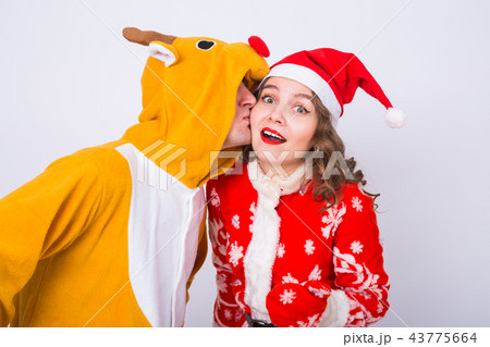 Happy young woman in santa claus hat and man in carnival costume of deer. Fun, holiday, joke and 43775664
