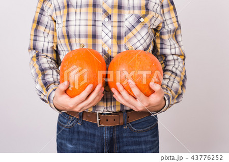 Agriculture, autumn, people concept - Close up of man farmer with two pumpkins on white background. 43776252