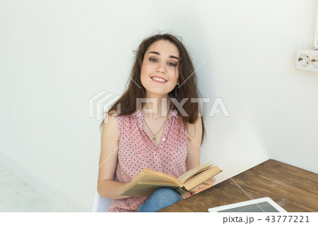 People, books and education concept - portrait of happy female student sitting with a book People, books and education concept - portrait of happy female student sitting with a book 43777221
