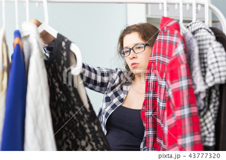 Clothing, fashion, style and people concept - woman choosing clothes at home wardrobe 43777320