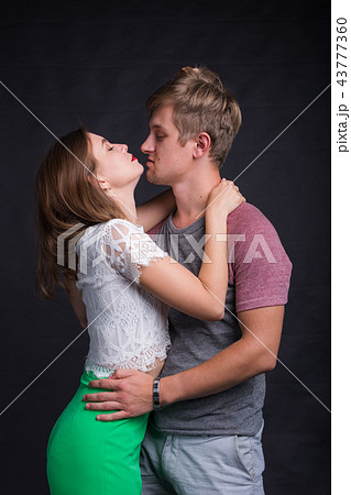 Lovers kissing each other on black background 43777360